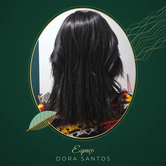 Cliente de costas com cabelo preto liso e brilhante, abaixo dos ombros, com camadas e pontas soltas, numa moldura dourada oval