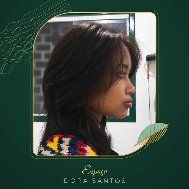 Cliente de perfil com cabelo castanho escuro em camadas, franja longa aberta no rosto e comprimento abaixo dos ombros, numa moldura dourada de cantos arredondados